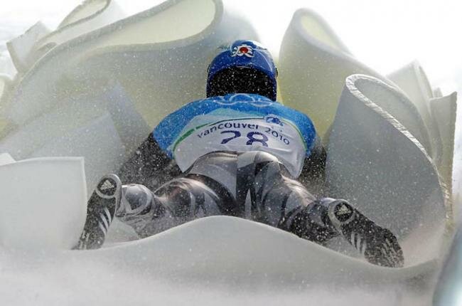 Японец Синсукэ Тамая тормозит о мягкий отбойник в финишной зоне во время тренировки по скелетону на Зимних Олимпийских играх в Ванкувере 15 февраля.